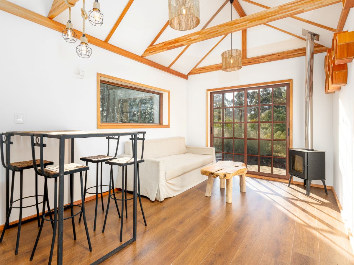 Heller Wohnraum eines Holzhauses mit sichtbarer Dachkonstruktion